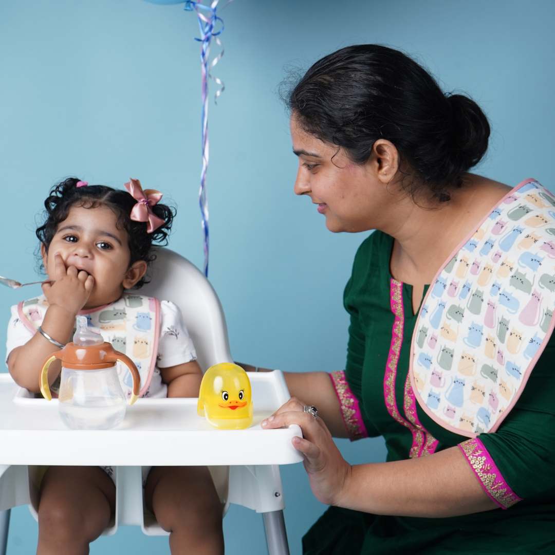 Baby-wearing-bib-and-mother-feeding-her.