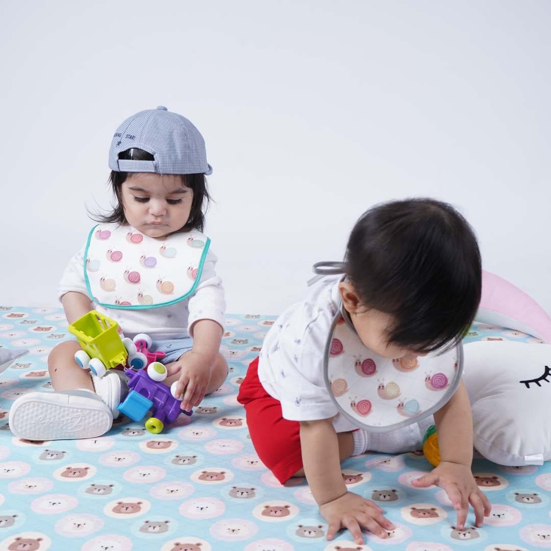 Two-Babies-Playing-on-crib-sheet-looking-down