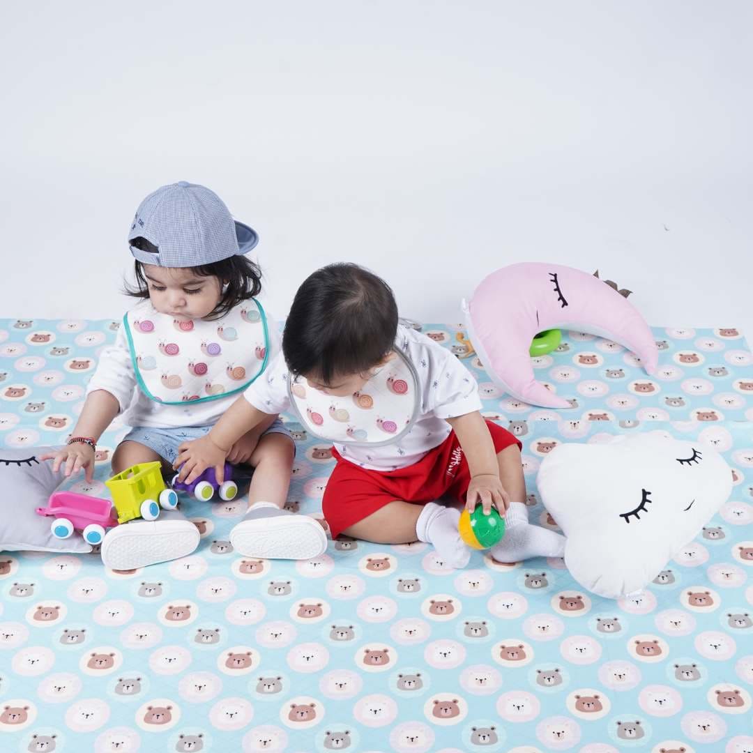 Two-Babies-Playing-on-crib-sheet-looking-down