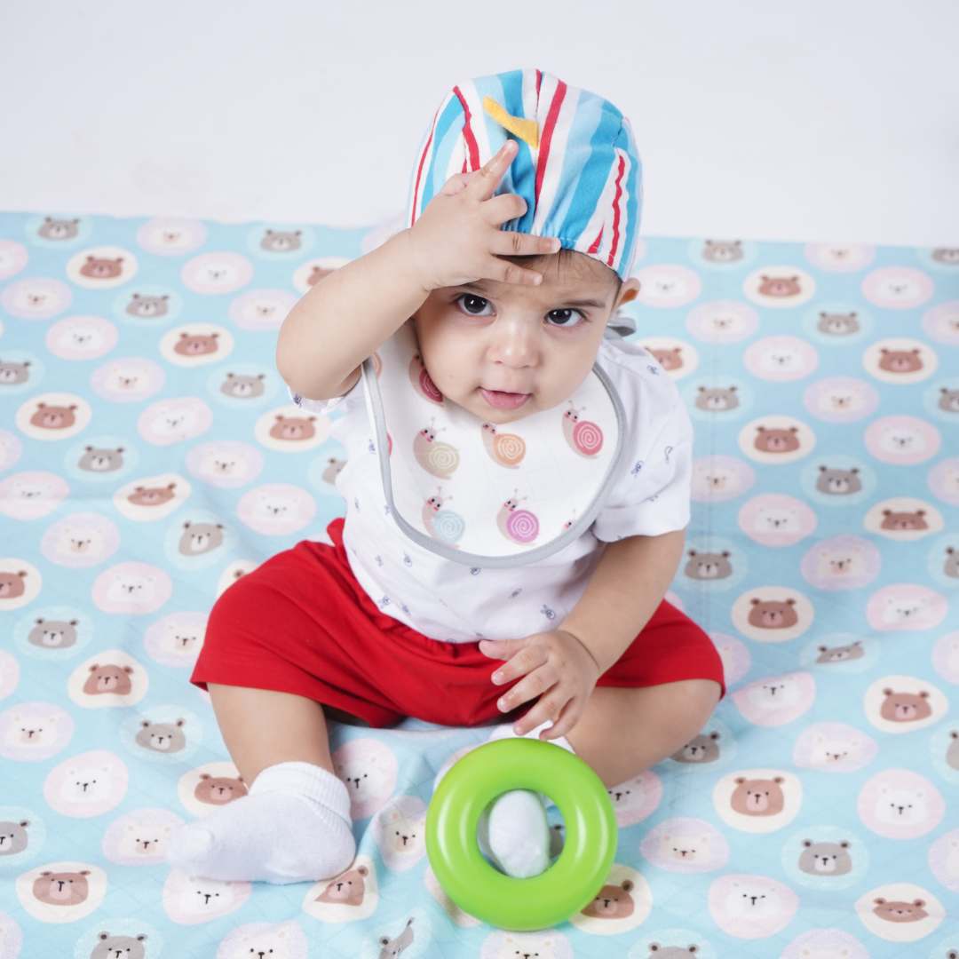 Baby-sitting-and-playing-on-crib-sheet