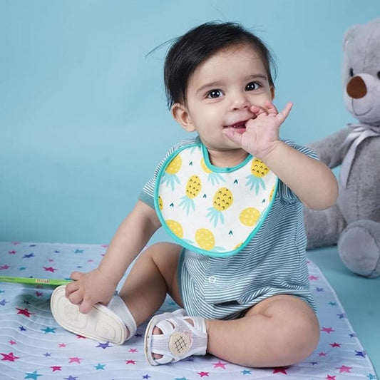 Baby-putting-finger-in-mouth-sitting-on-playmat